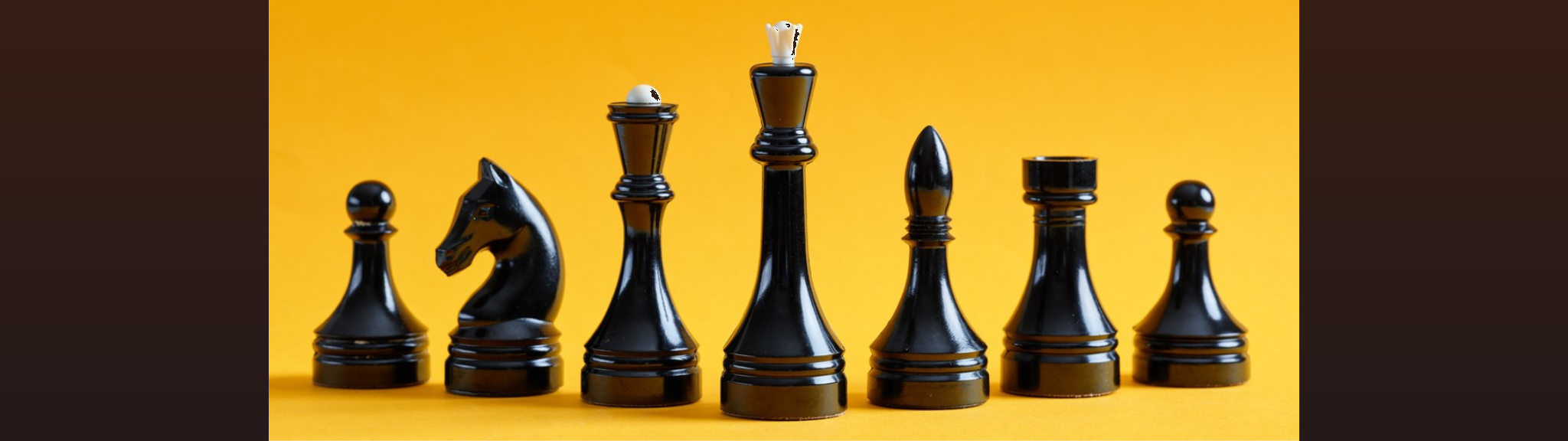 Black chess pieces with a yellow background
